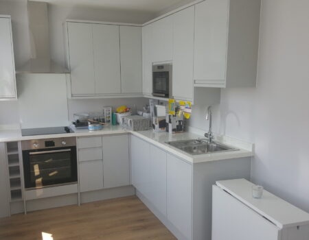 Top Drawer Construction white and chrome kitchen fitted in studio apartment Woking Surrey