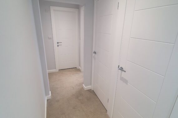 Top Drawer Construction bespoke carpentry white doors fitted in an apartment hallway Woking Weybridge Surrey